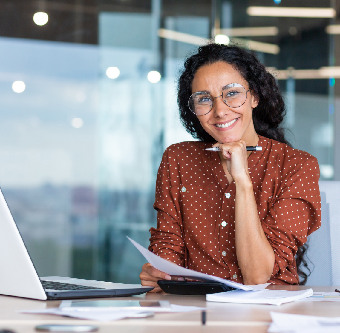 Femme assise à son bureau, de face, souriante