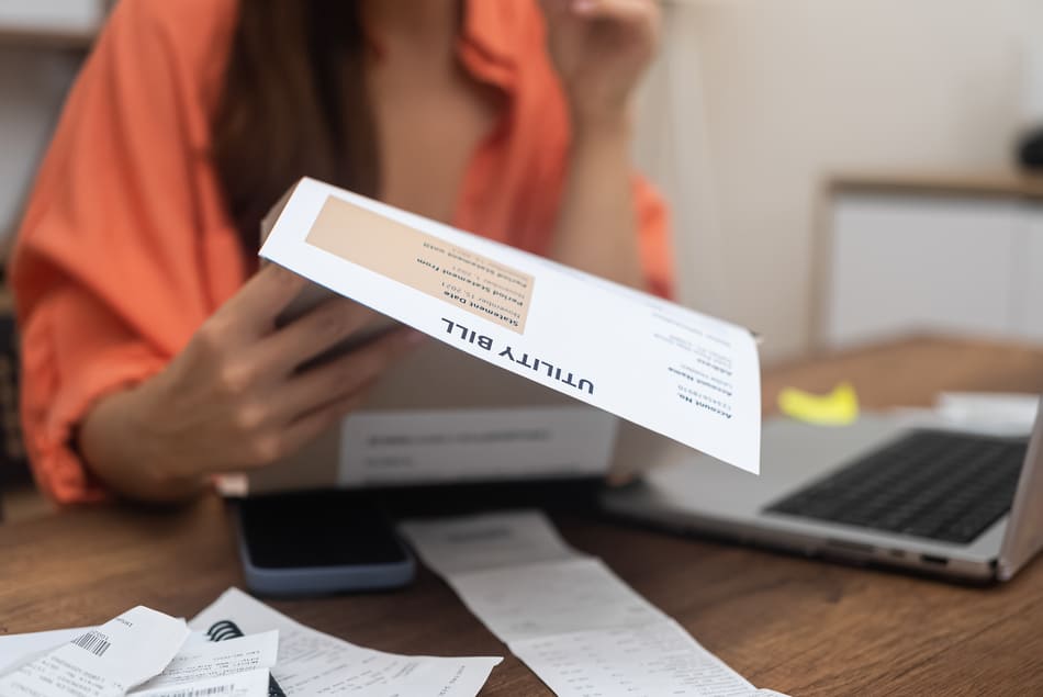 Plan serré sur la main d'une collaboratrice tenant une facture dans sa main