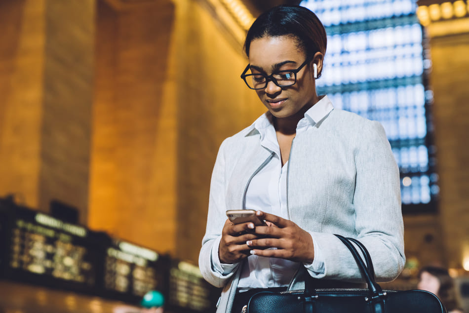Woman using her smartphone on a train station