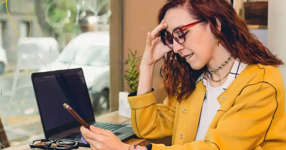 Young caucasian female freelance working and looking at her phone