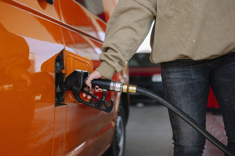 Woman filling the tank of her orange vehicle